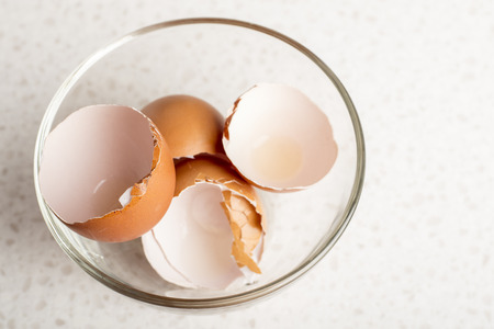 egg shells in a glass bowl on a white table. Kitchen. Copy space 1の写真素材