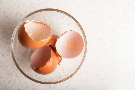 egg shells in a glass bowl on a white table. Kitchen. Copy space 1