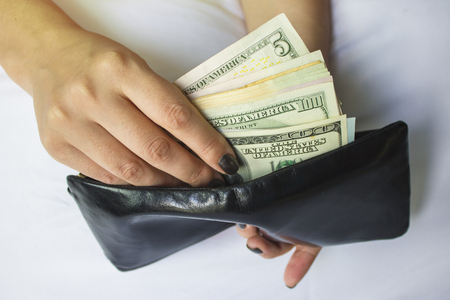Hands hold dollar bills and a small money bag. Different banknotes 1の写真素材