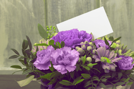 Abstract background. Fresh flowers with a white card. Copy spaceの写真素材