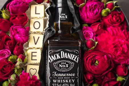NOVOSIBIRSK, RUSSIA - FEBRUARY 23, 2018 - gift wrapping of JackDaniels whiskey. Belgian white chocolate with the inscription Love. Flowers and alcoholのeditorial素材