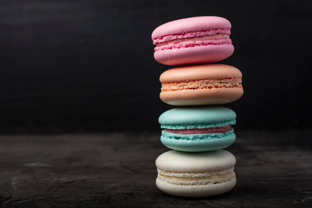 Colorful pastry. Cookie macaron or macaroon on a dark background. Copy space 1
