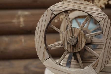An old wooden wheel on the background of an old log house, in the villageの写真素材