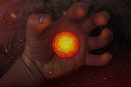 The hot coin Bitcoin lies on his hand. Hot moneyの写真素材