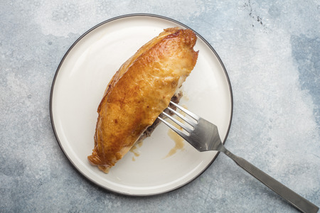 Fried chicken breast on a white plate. A golden crust. View from aboveの写真素材