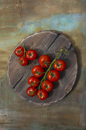 Ripe tomato branch on a wooden table, close-up. View from aboveの写真素材