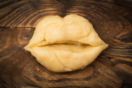 dough for cookies in the form of female lips on a wooden background. Copy space