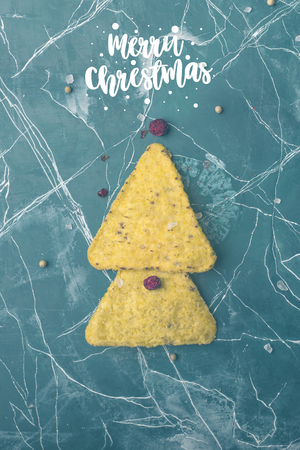 Corn tortillas with cheese. The concept of the new year from the Mexican nachos. Christmas trees from nacho chips on a blue background. View from above. Copy spaceの写真素材