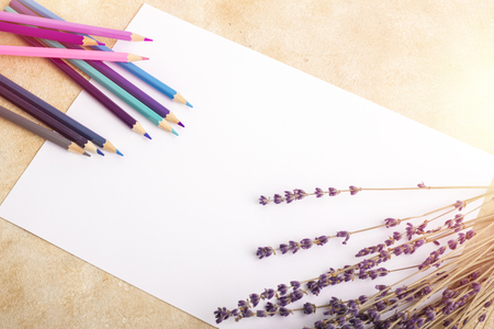 Mock up of blank sheet, colored pencils and branches of lavender on the table. Place for your designの写真素材