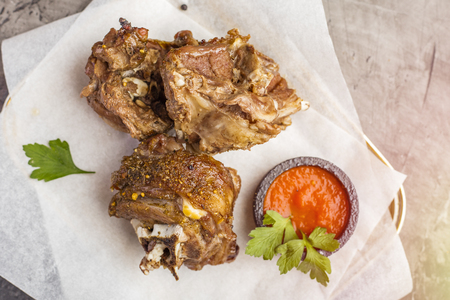 Roasted lamb meat on food paper with tomato sauce. View from above. Copy spaceの写真素材