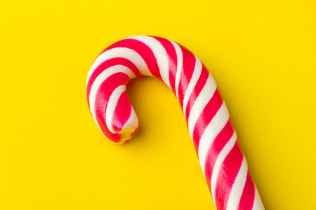 Christmas Candy Cane with Red Bow on yellow Background. Copy spaceの写真素材