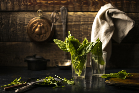 Fresh leaves of sorrel in a glass cup on a table in the kitchen. wooden background. Copy spaceの写真素材