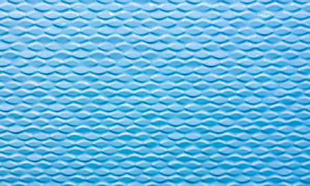 Wall of ceramic tiles with textured waves. Blue color tiles. Background, texture