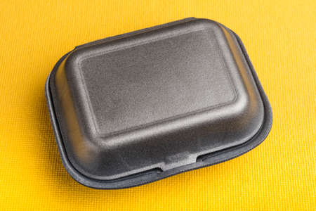 Black closed box on yellow background. Food box for food to go, deliveryの写真素材