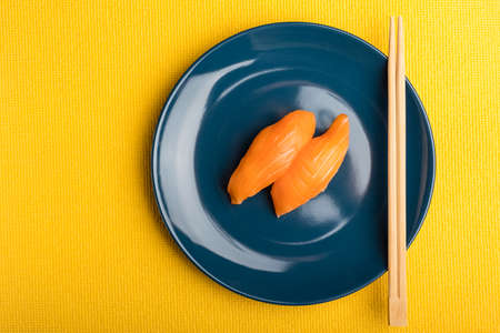 Sushi with salmon and sticks on a blue plate. Serving Japanese food. Top view with copy spaceの写真素材
