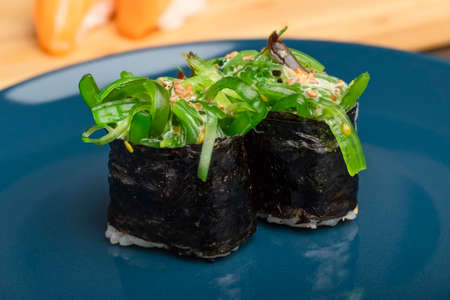Two chukka gunkan seaweed sushi rolls on a blue plate. Serving Japanese foodの写真素材