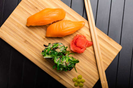 sushi with salmon and seaweed rolls on a bamboo packing board. Serving Japanese food. Top viewの写真素材