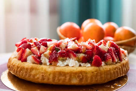 Berry pie on the festive table. delicious pie with cream and fresh strawberry slicesの写真素材
