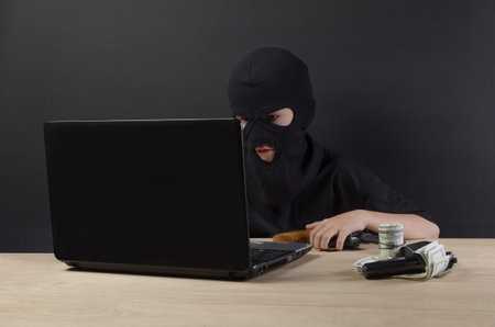 THE LITTLE BOY IN THE MASK OF THE TERRORIST BEHIND A LAPTOP