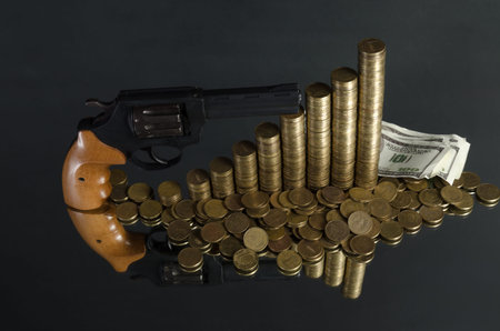 arrangement of coins and gun on grey background