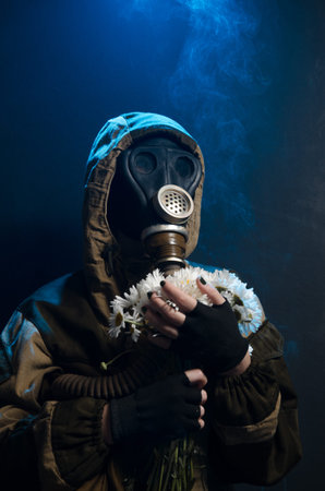 the photo of girl in gas mask on grey background c daisies