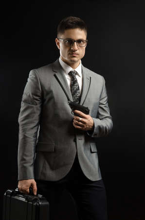 a man in a suit jacket with a gun posing as a special agentの写真素材