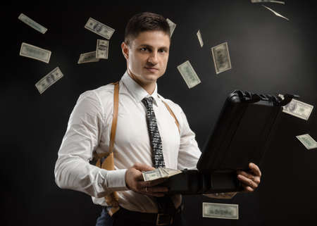 a man in a suit jacket with a case of moneyの写真素材