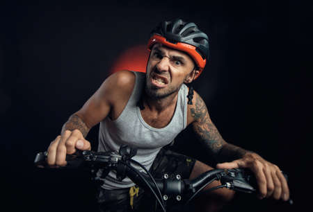 guy in a Bicycle helmet emotionally posing on a black backgroundの写真素材