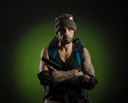 man with gun and backpack on dark background
