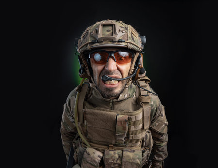 a male soldier in military clothes with a weapon on a dark background