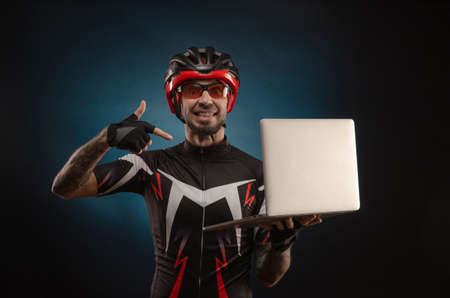 guy-cyclist in a Bicycle helmet with a laptopの写真素材