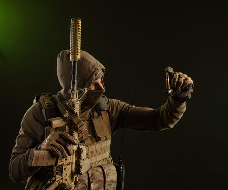 a soldier-saboteur in military uniform with a weapon on a dark background shows a bullet