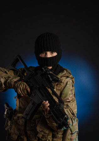boy in military uniform and Balaclava with weapons