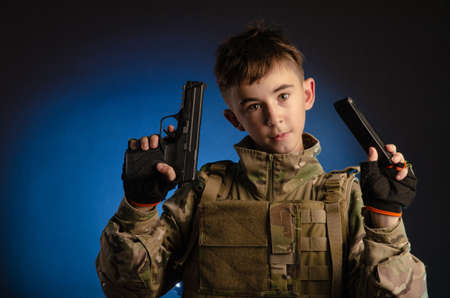 a boy in military uniform with a gunの写真素材
