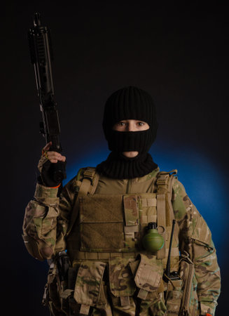 boy in military uniform and Balaclava with weapons