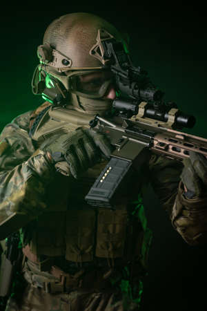 a soldier in military clothing with a night vision device and on a dark backgroundの写真素材