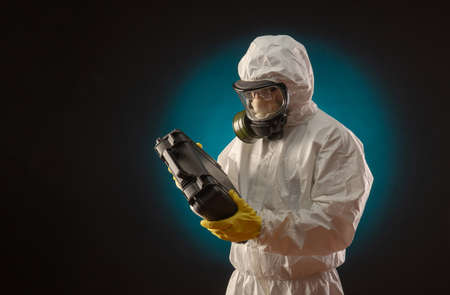 a man in a biological protective suit wearing a gas mask with medication for coronavirusの写真素材