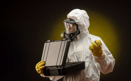 a man in a biological protective suit wearing a gas mask with medication for coronavirusの写真素材