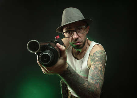 an athletic guy with a tattoo poses with a shotgunの写真素材