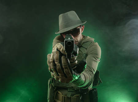 an athletic guy poses with a pistolの写真素材
