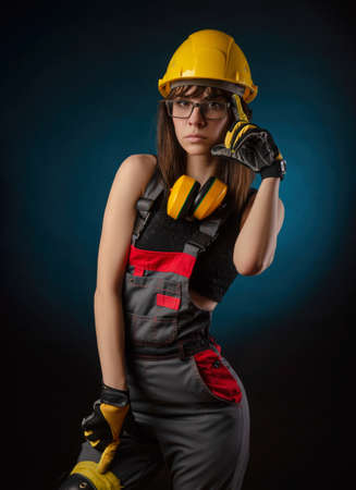 Girl in overalls with a chainsawの写真素材