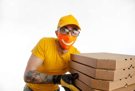 the guy delivering packages in a virus-proof mask, the courier with pizzaの写真素材