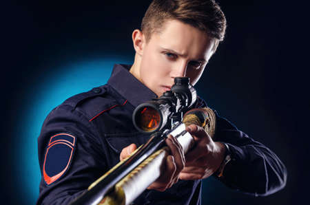 a guy in a police uniform with a sniper rifleの写真素材