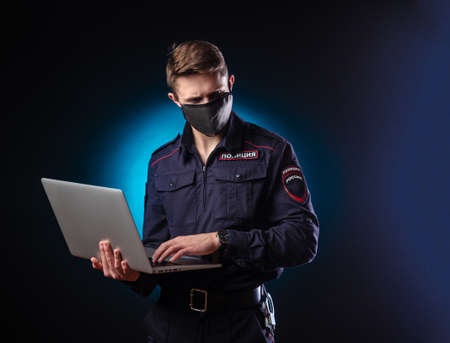 a handsome guy in a police uniform with a laptop on his face and a medical mask . English translation of Policeの写真素材