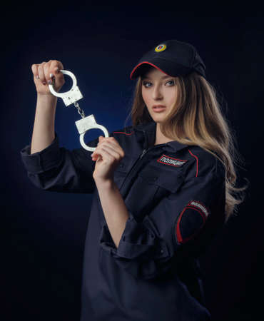 girl in police uniform with a gun-Russian police officer with handcuffs. English translation of Policeの写真素材
