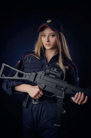 the girl in the police uniform with a gun is a Russian policeman with gun. English translation of Policeの写真素材