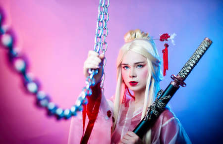 a woman in a geisha costume with a katana next to the chainsの写真素材