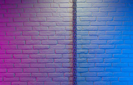white brick wall texture with chain in neon lightの写真素材