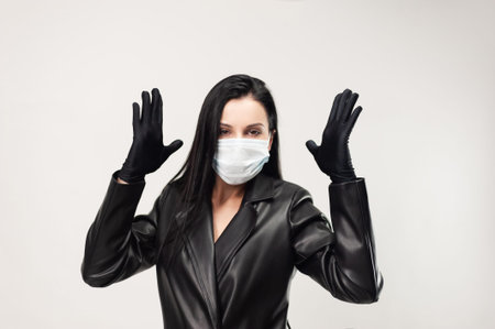 A woman in black leather clothing with a medical mask protection from coronavirus