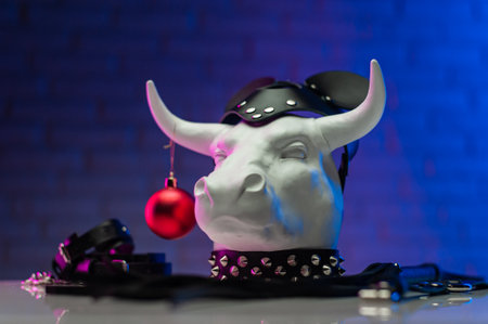 white metal bull figurine with a new years toy in a leather mask and accessories for BDSM gamesの写真素材